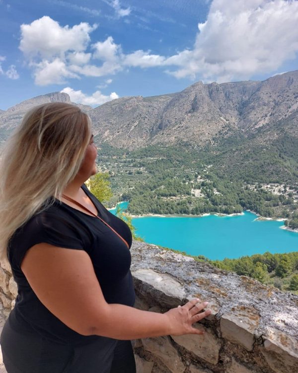 Milagro mirando un embalse turquesa entre montañas